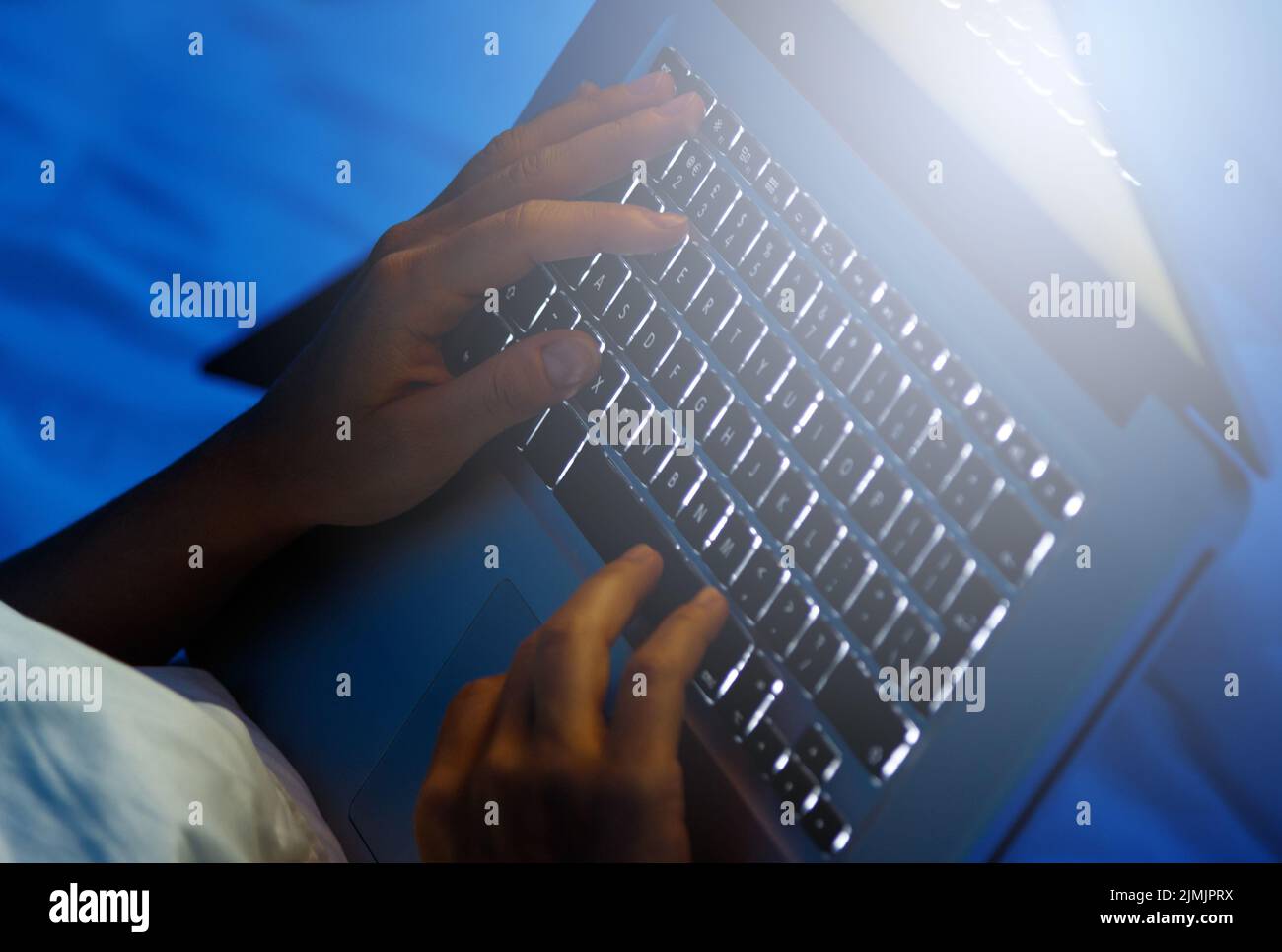 Mujer con las manos en el teclado del ordenador portátil por la noche Foto de stock