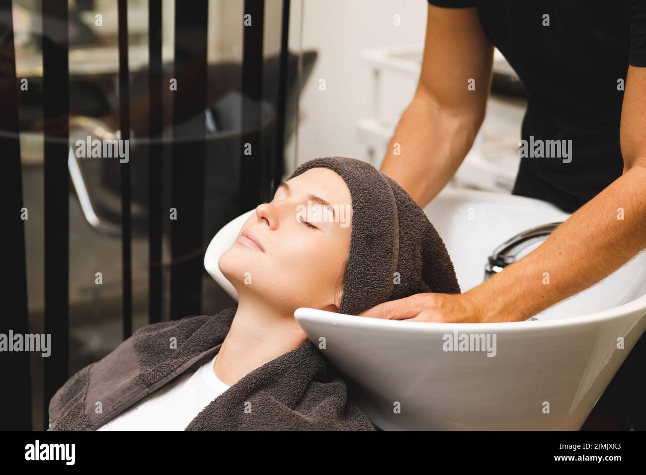 Mujer en el salón de peluquería durante el lavado de cabello después del corte de pelo Foto de stock