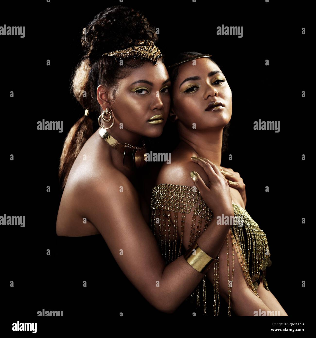 Bienvenido a nuestro Queendom. Retrato de dos mujeres jóvenes atractivas y elegantemente vestidas posando juntas sobre un fondo oscuro. Foto de stock