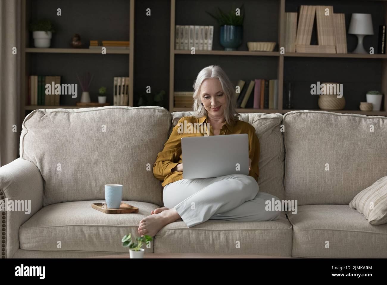 Feliz mujer jubilada descansando en un sofá en casa Foto de stock