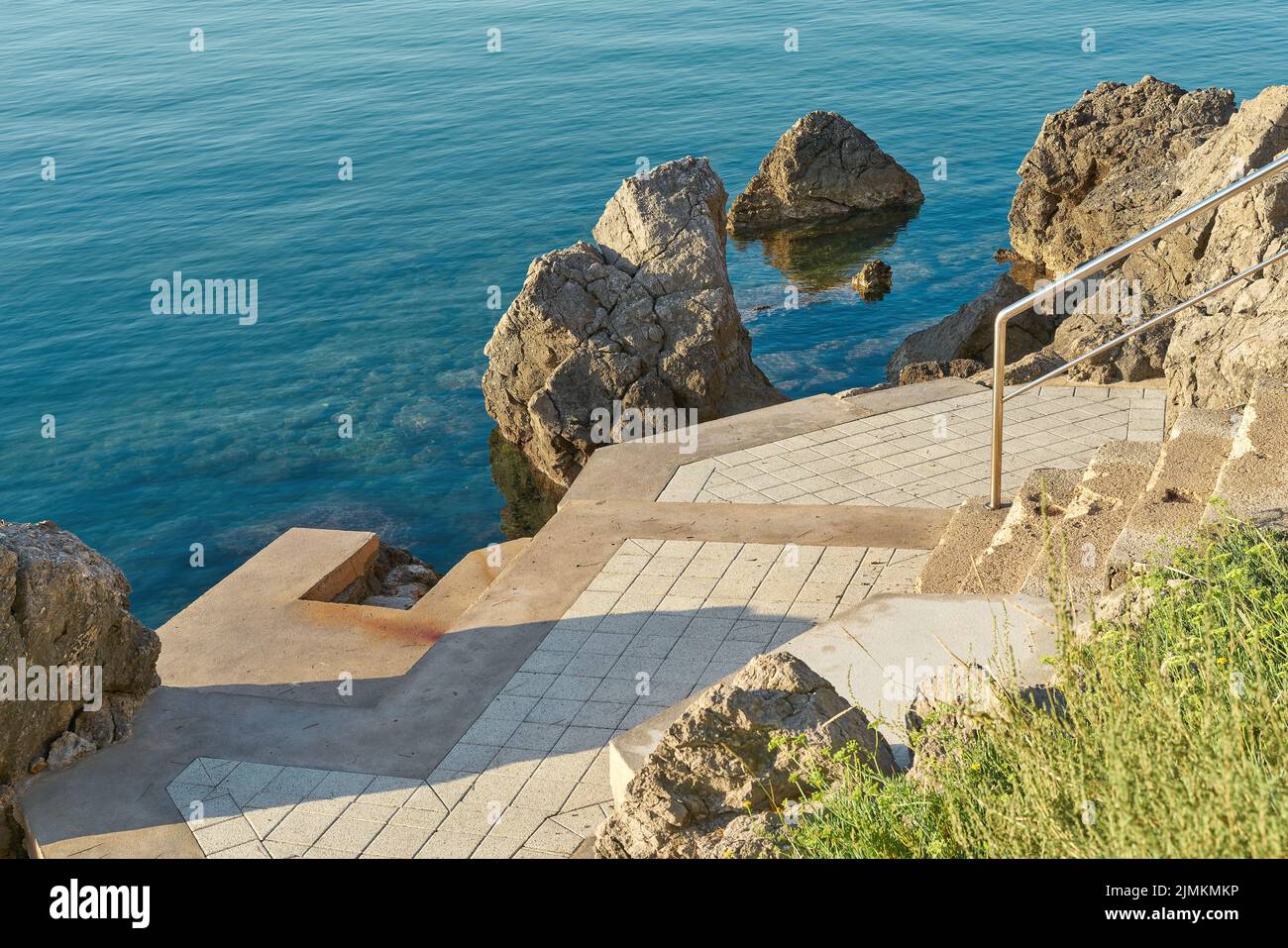 Típico lugar de baño en la costa rocosa cerca de Krk en el mar Adriático en Croacia Foto de stock