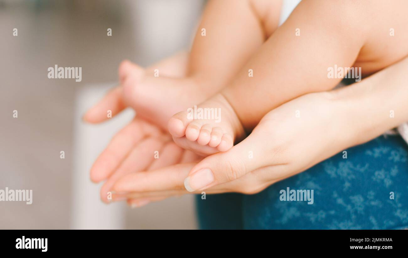 feliz maternidad tierna protección del amor de los pies del bebé Foto de stock