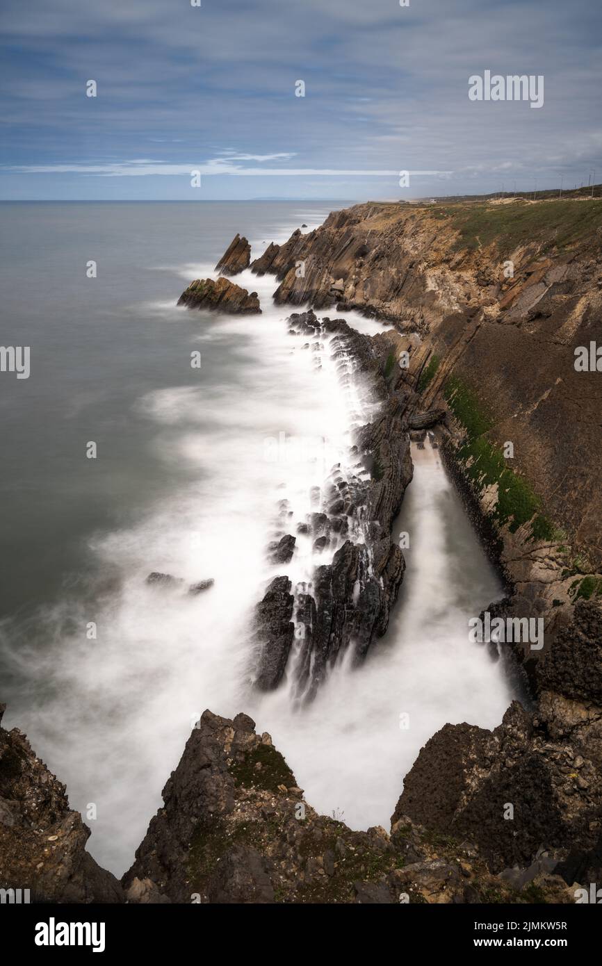 Una vista vertical de larga exposición de la costa rocosa y salvaje en el océano Altlantic Foto de stock