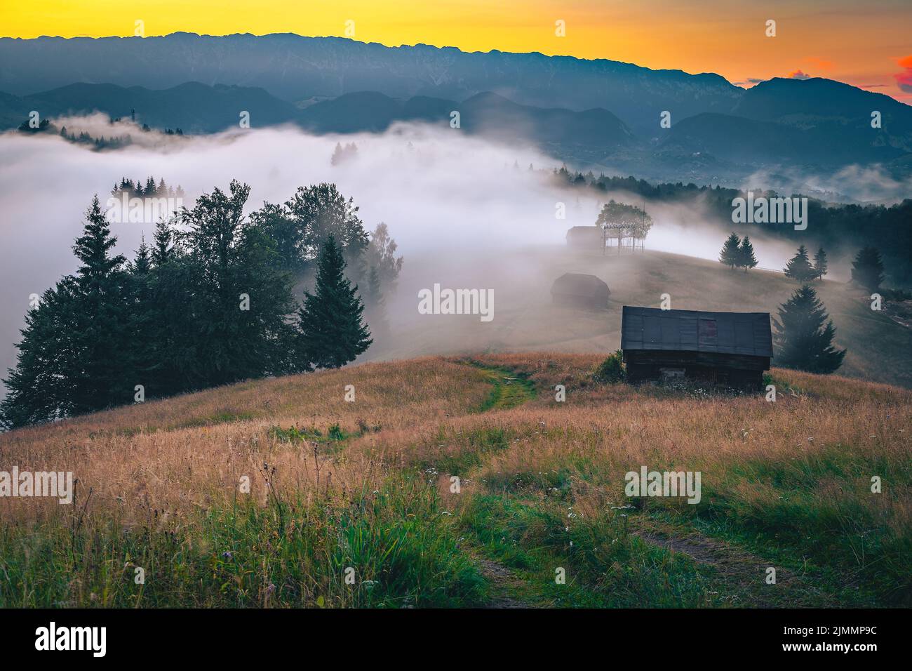 Impresionante paisaje de otoño con laderas brumosas y valles después de la lluvia al atardecer, Transilvania, Rumanía, Europa Foto de stock