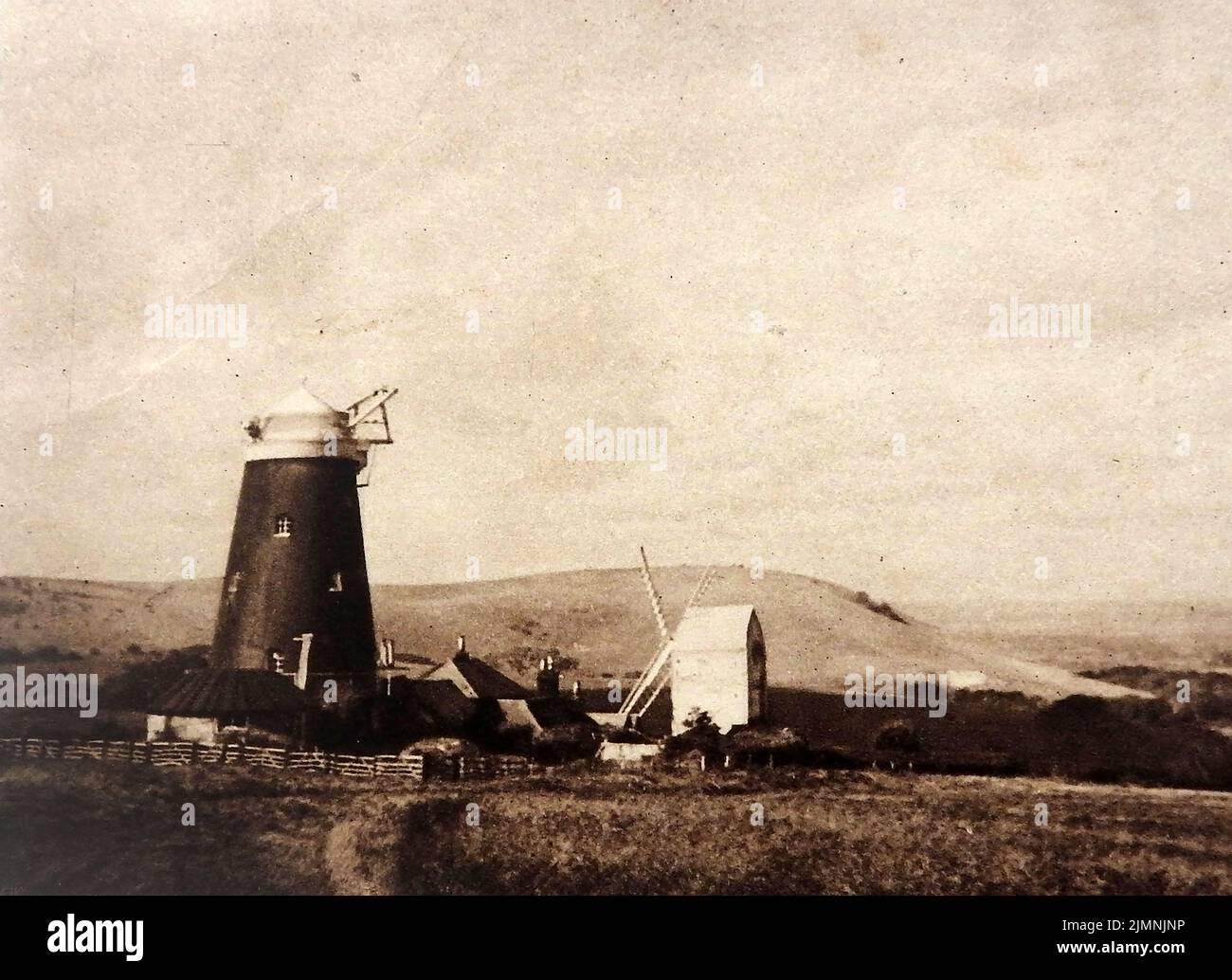 Una fotografía antigua que muestra dos tipos de molinos de viento británicos Foto de stock
