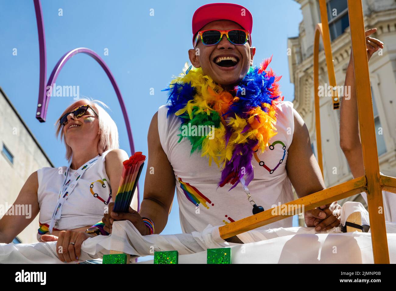 Brighton, Reino Unido. 6th de agosto de 2022. Un juerguero que lleva guirnalda y gafas de sol Pride sonríe desde la parte superior de un autobús de dos pisos durante el 30th aniversario del desfile de la comunidad LGBTQ+ de Brighton & Hove Pride. Brighton & Hove Pride tiene la intención de celebrar y promover el respeto, la diversidad y la inclusión dentro de la comunidad local, así como apoyar a las organizaciones benéficas y causas locales a través de la recaudación de fondos. Crédito: Mark Kerrison/Alamy Live News Foto de stock