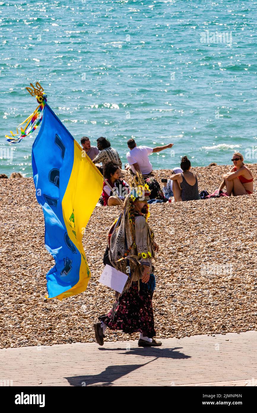 Brighton, Reino Unido. 6th de agosto de 2022. Un hombre con una bandera ucraniana camina por la playa con motivo del 30th aniversario del desfile de la comunidad LGBTQ+ de Brighton & Hove Pride. Brighton & Hove Pride tiene la intención de celebrar y promover el respeto, la diversidad y la inclusión dentro de la comunidad local, así como apoyar a las organizaciones benéficas y causas locales a través de la recaudación de fondos. Crédito: Mark Kerrison/Alamy Live News Foto de stock