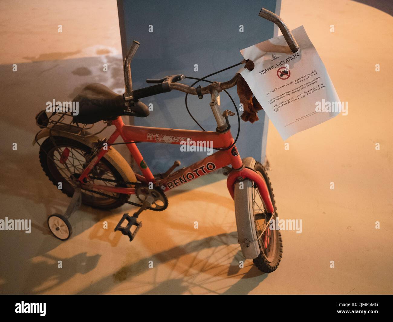 Bicicleta infantil con estabilizadores y aviso de infracción de tráfico adjunto a manillar, Emiratos Árabes Unidos, Dubai, Emiratos Árabes Unidos, Foto de stock