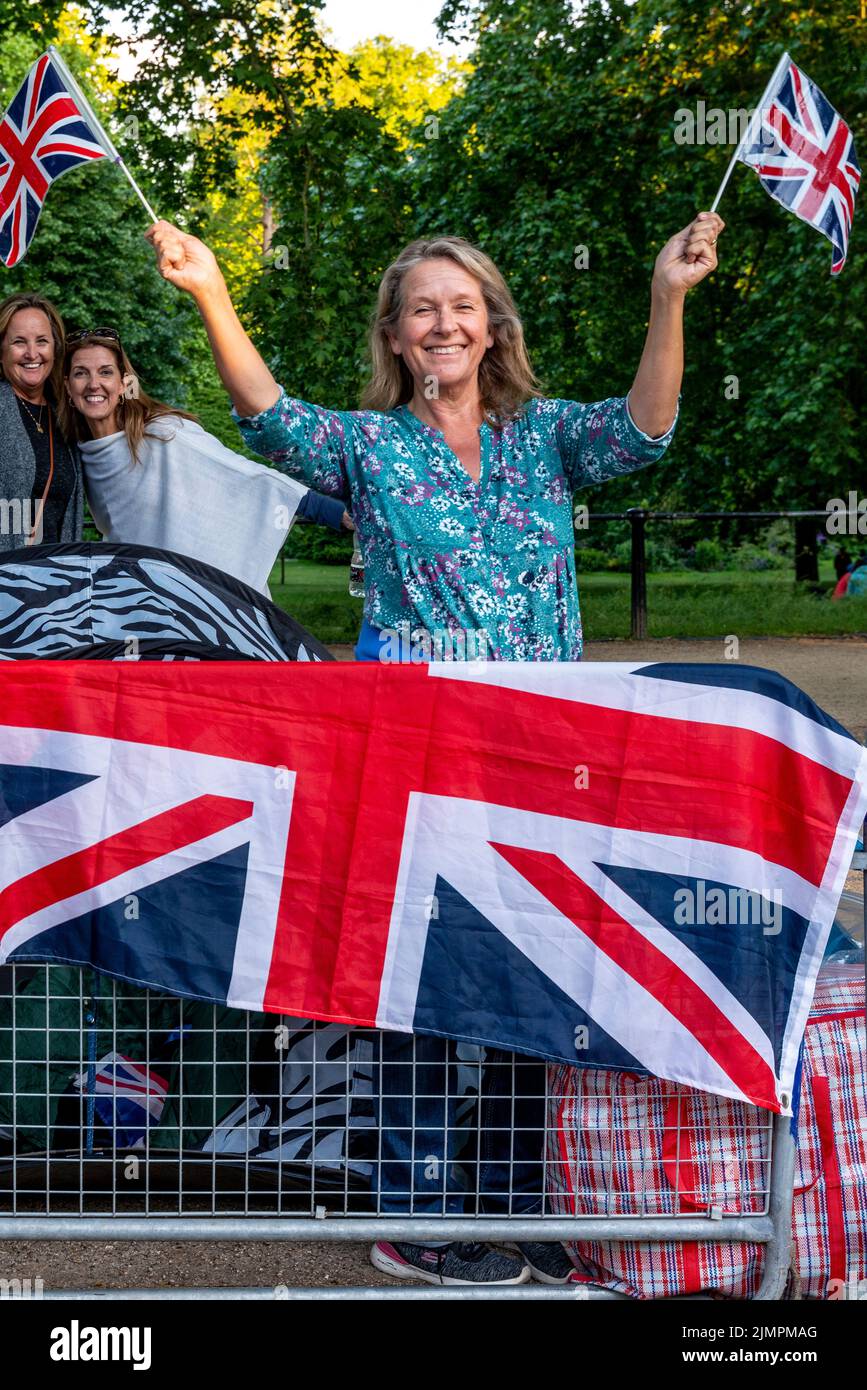 Una mujer británica ondea con Union Flags antes del desfile de cumpleaños de la reina, The Mall, Londres, Reino Unido. Foto de stock