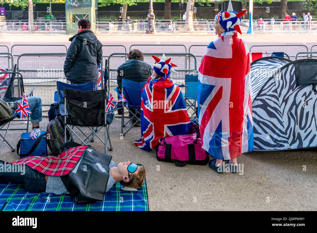 La gente se despierta después de acampar por la noche en el centro comercial para ver el desfile del cumpleaños de la reina durante las celebraciones del jubileo de platino de la reina, Londres, Reino Unido Foto de stock
