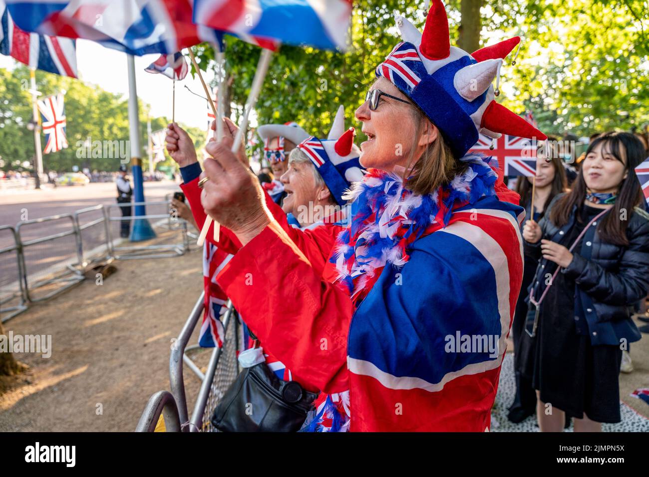 Un grupo de gente británica que acampó fuera de la noche a lo largo del centro comercial canta el himno nacional para el beneficio de la prensa extranjera, Londres, Reino Unido. Foto de stock