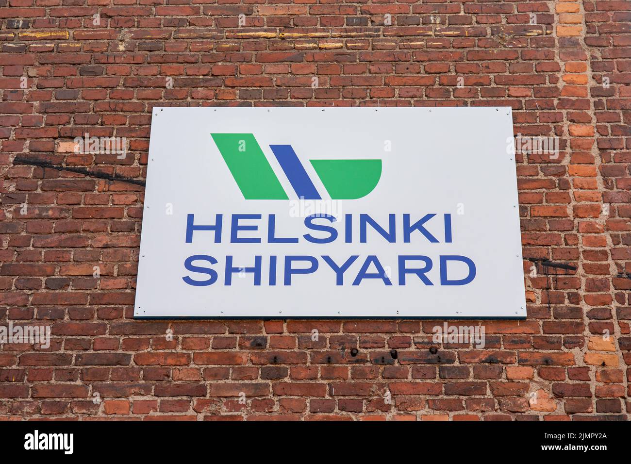 Cartel o cartel del astillero de Helsinki en la pared de ladrillo rojo del distrito Munkkkkisaari de Helsinki, Finlandia Foto de stock