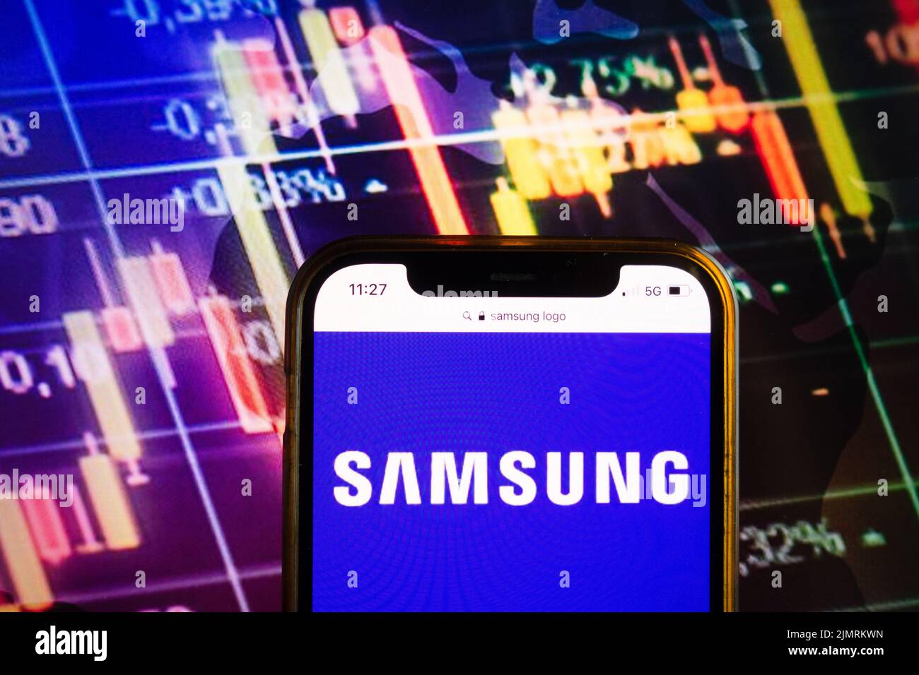 El logotipo de Samsung de la cotización de las acciones en la pantalla del  smartphone en manos de los hombres con la tendencia cambiante en el gráfico  en el fondo, febrero de