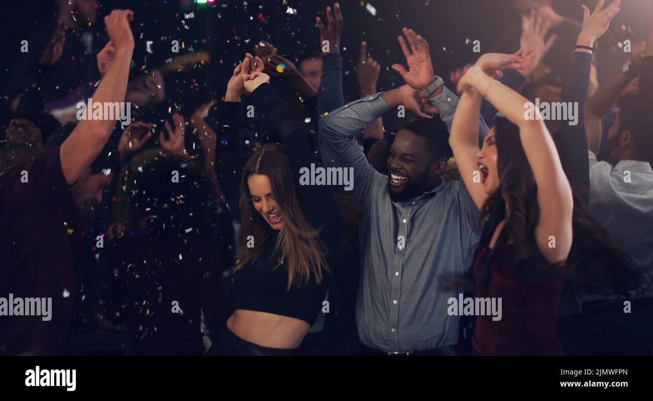Es una celebración de Año Nuevo. Un grupo de jóvenes amigos bailando juntos en un club nocturno. Foto de stock