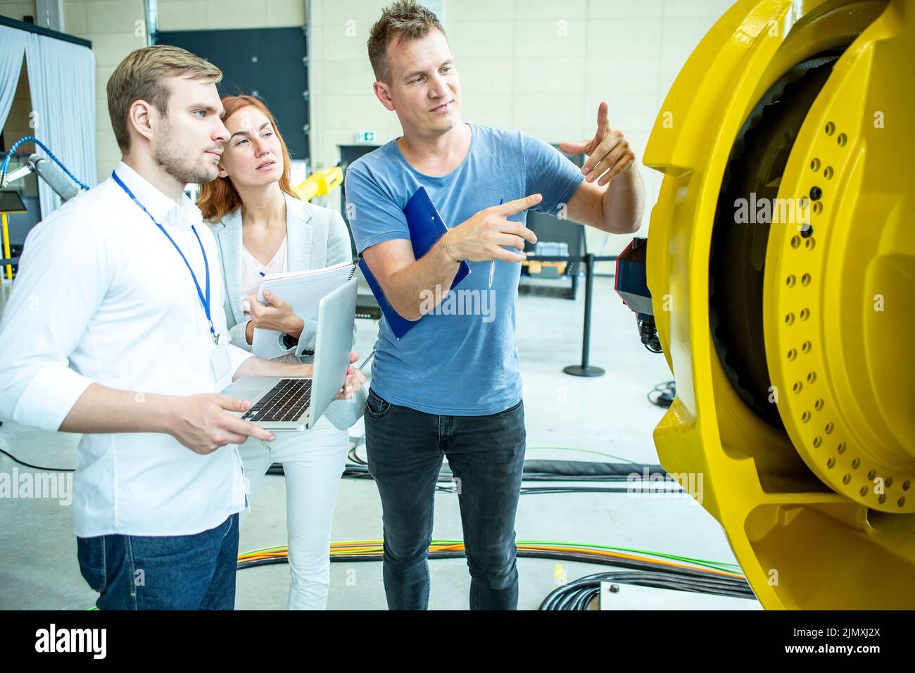 Los ingenieros inspeccionan el robot industrial Foto de stock