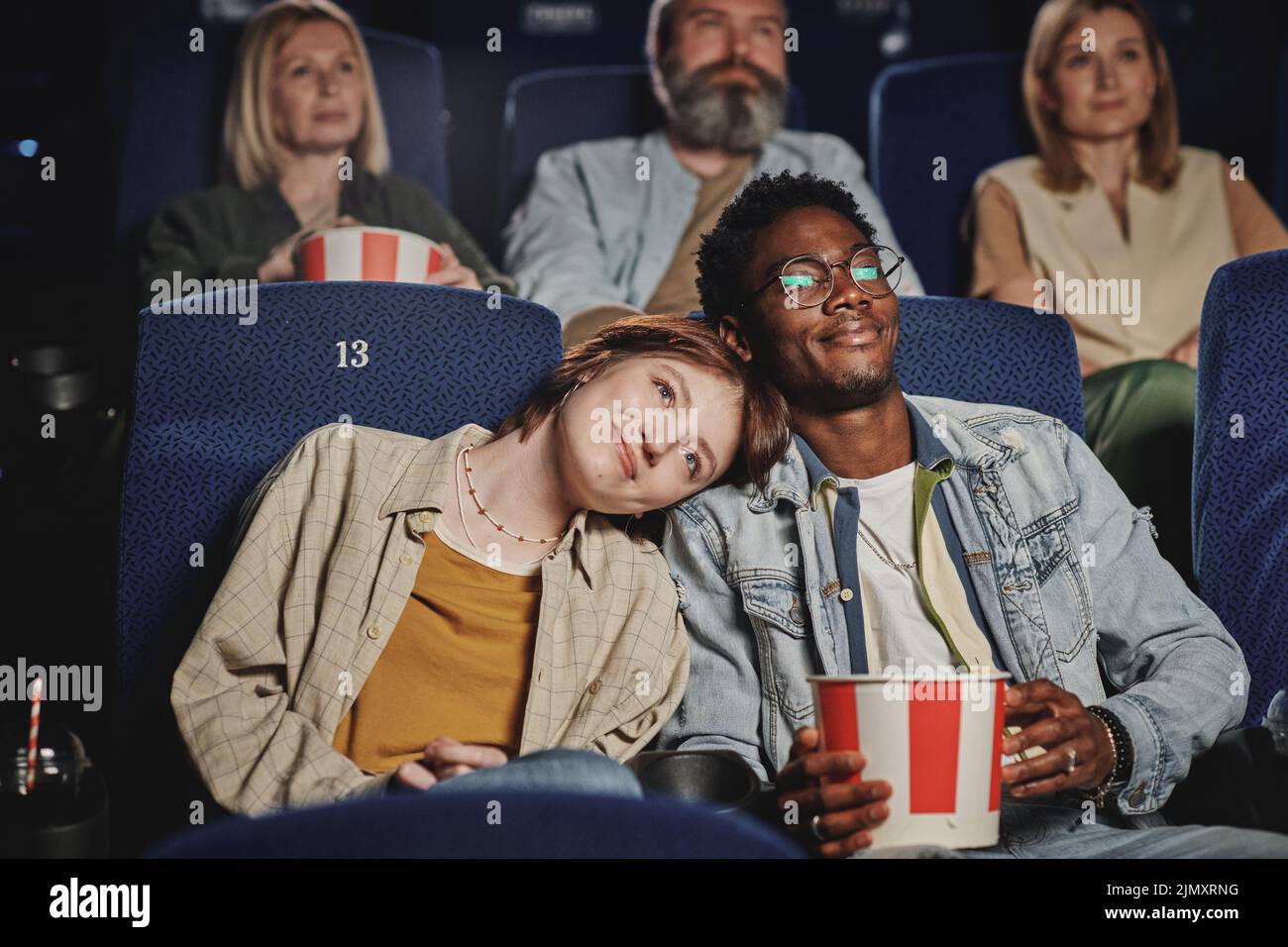 Retrato de una moderna pareja joven, étnicamente diversa, pasando la noche en el cine Foto de stock