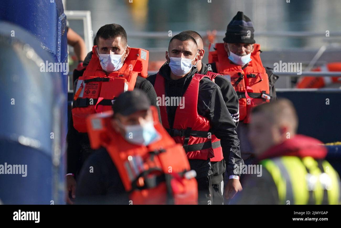 Un grupo de personas que se cree que son inmigrantes son llevadas a Dover, Kent, desde un barco de la Fuerza Fronteriza, después de un pequeño incidente en el Canal de la Mancha. Fecha de la foto: Lunes 8 de agosto de 2022. Foto de stock
