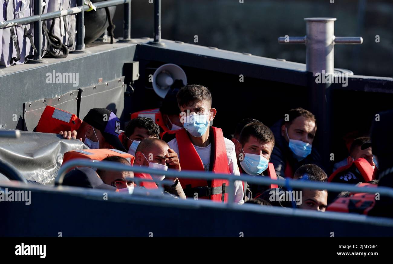 Un grupo de personas que se cree que son inmigrantes son llevadas a Dover, Kent, desde un barco de la Fuerza Fronteriza, después de un pequeño incidente en el Canal de la Mancha. Fecha de la foto: Lunes 8 de agosto de 2022. Foto de stock