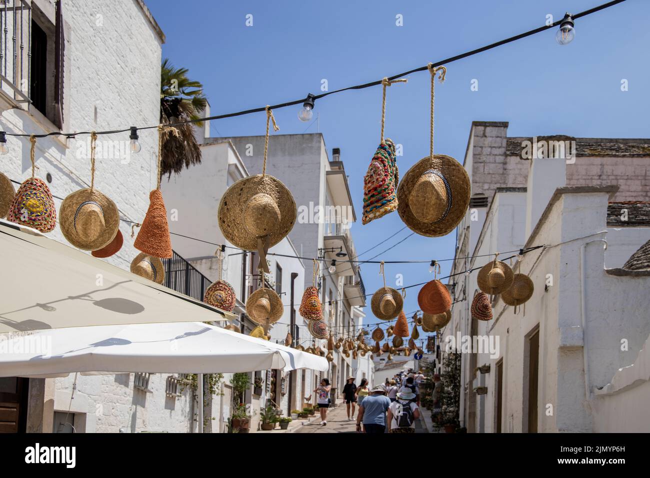 sombreros cubren 0ne de las principales calles de locorotondo, una ciudad de puglia, italia, famosa por sus casas de trulli circulares en forma de cono Foto de stock