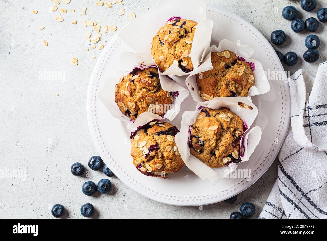 Avena vegana, plátano, muffins de arándanos sobre fondo gris, vista
