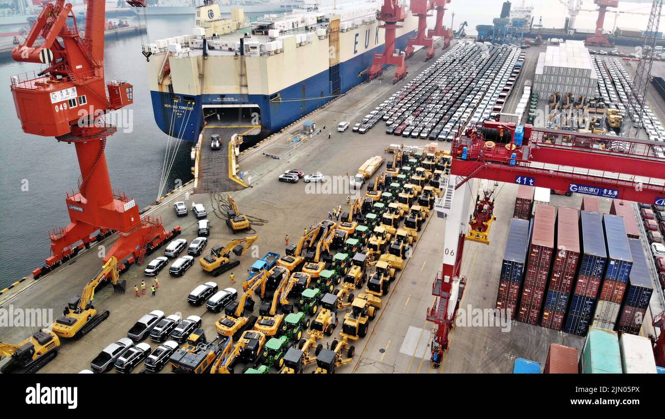 Qingdao. 7th de Ago de 2022. Foto aérea tomada el 7 de agosto de 2022 muestra vehículos comerciales antes de su embarque en un buque de carga de ro-ro para salir hacia África en el puerto de Qingdao en Qingdao, en la provincia de Shandong en el este de China. Con mucho este año, el volumen de exportación de vehículos comerciales del puerto de Qingdao ha crecido más del 90 por ciento año con año. Crédito: Li Ziheng/Xinhua/Alamy Live News Foto de stock