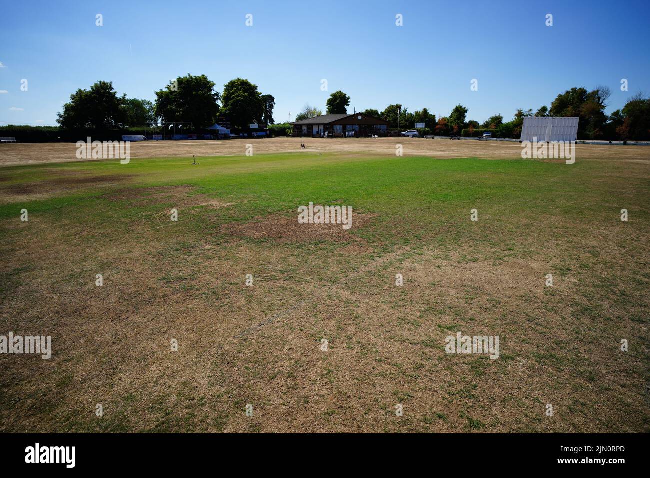 Hierba seca en el campo de cricket en el pueblo de Odiham en Hampshire. Gran Bretaña está preparada para otra ola de calor que durará más que el período de calor récord de julio, con máximos de hasta 35C que se esperan la próxima semana. Fecha de la foto: Lunes 8 de agosto de 2022. Foto de stock