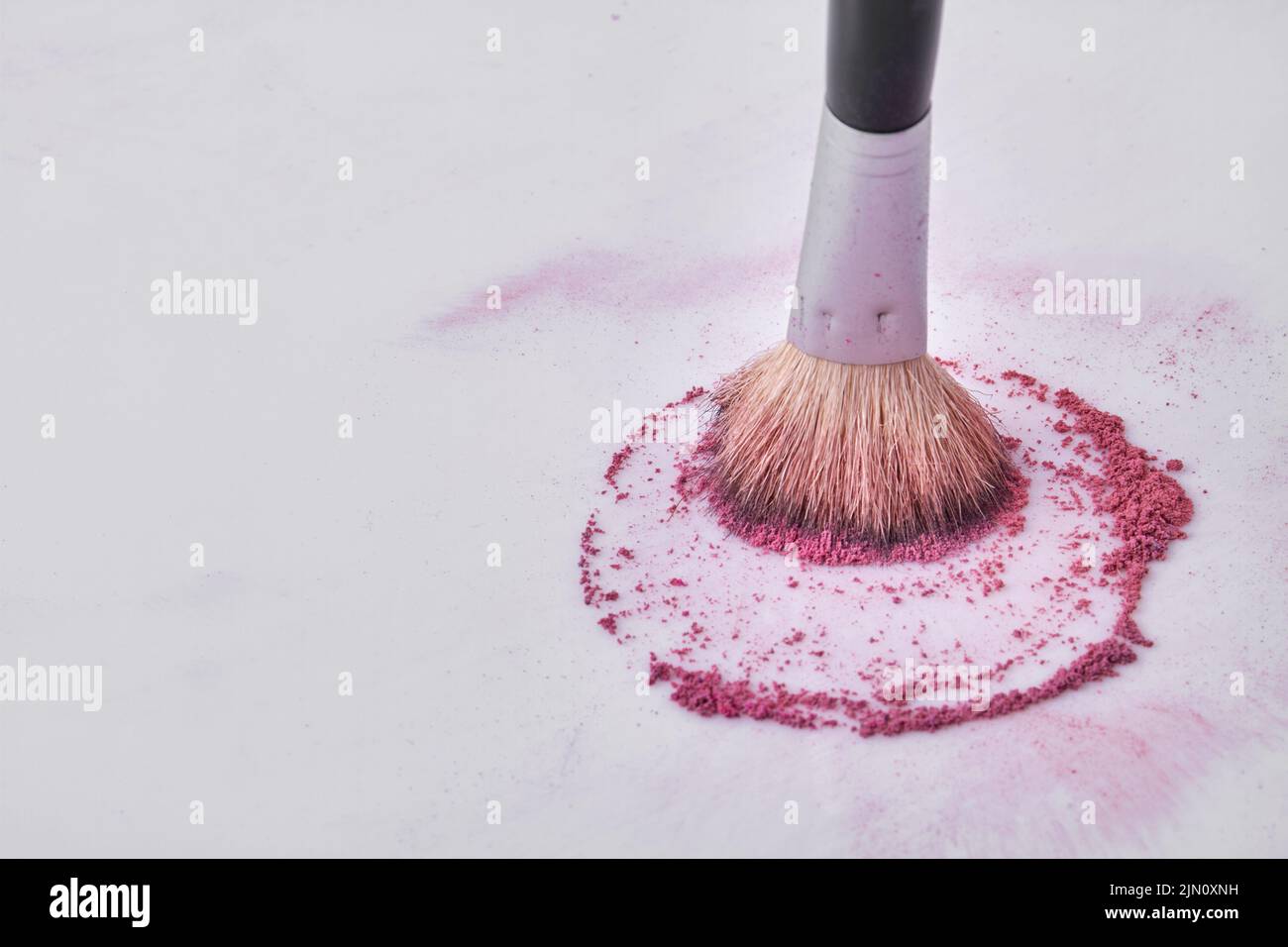 Primer plano cepillo de maquillaje con polvo púrpura. Espacio libre para texto. Foto de stock