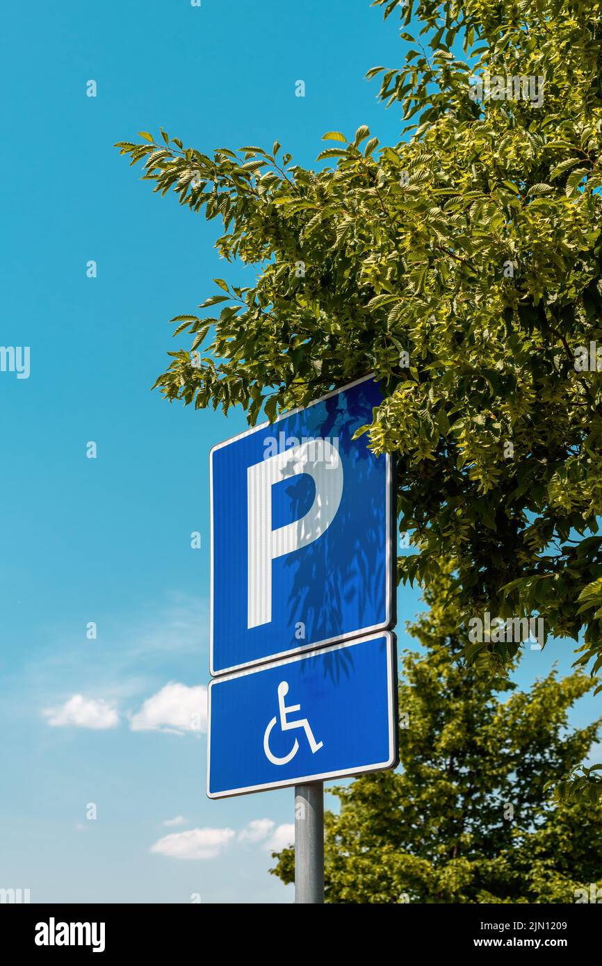 Señal de plaza de aparcamiento reservada, pictograma de persona discapacitada con discapacidad en silla de ruedas, enfoque selectivo Foto de stock