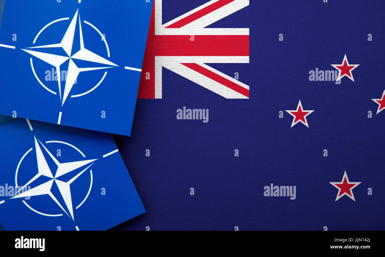 LONDRES, Reino Unido - Agosto de 2022: Logotipo de alianza militar de la Organización del Tratado del Atlántico Norte (OTAN) en una bandera de Nueva Zelanda Foto de stock