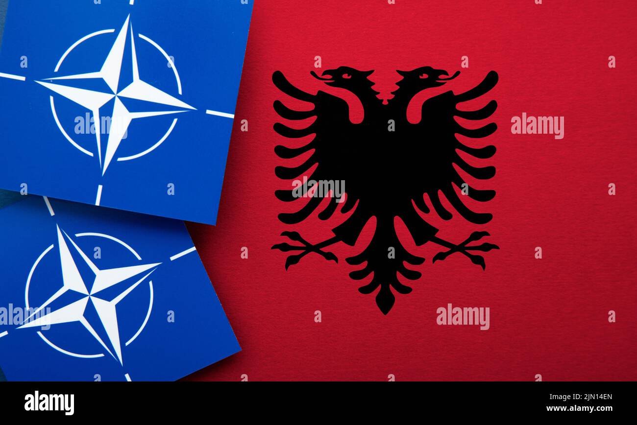 LONDRES, Reino Unido - Agosto de 2022: Logotipo de alianza militar de la Organización del Tratado del Atlántico Norte (OTAN) en una bandera de Albania Foto de stock