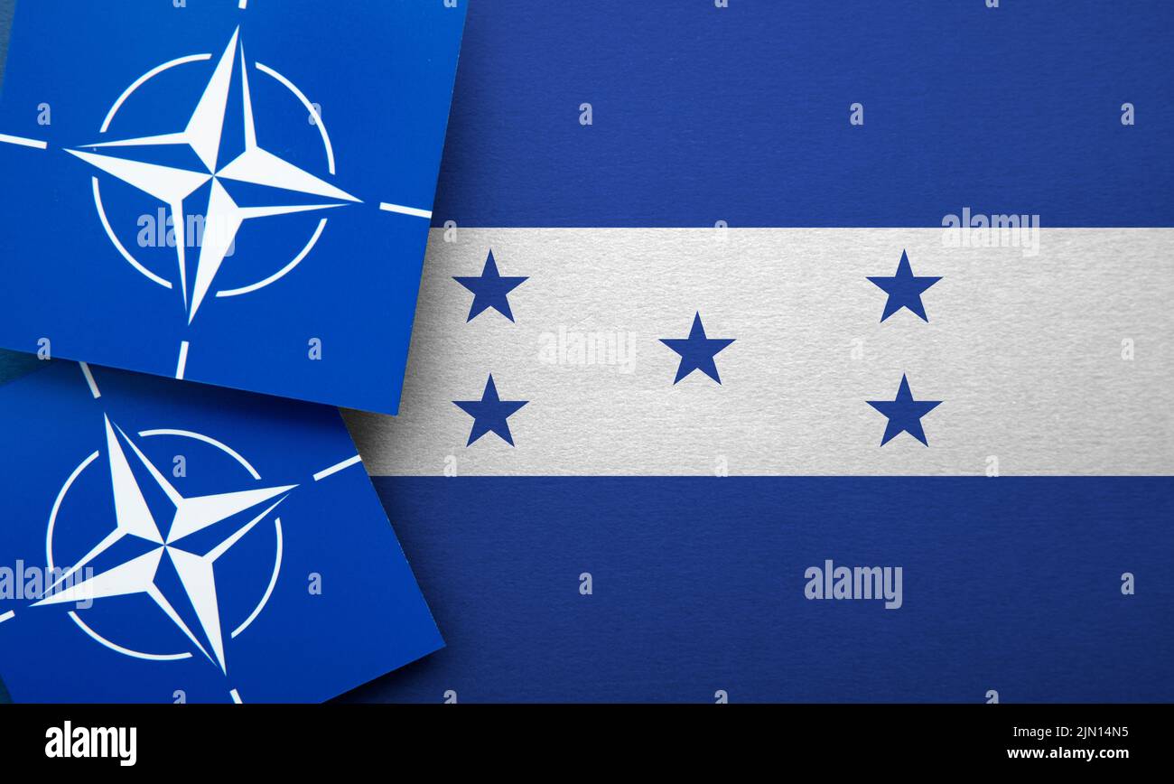 LONDRES, Reino Unido - Agosto de 2022: Logotipo de alianza militar de la Organización del Tratado del Atlántico Norte (OTAN) en una bandera de Honduras Foto de stock