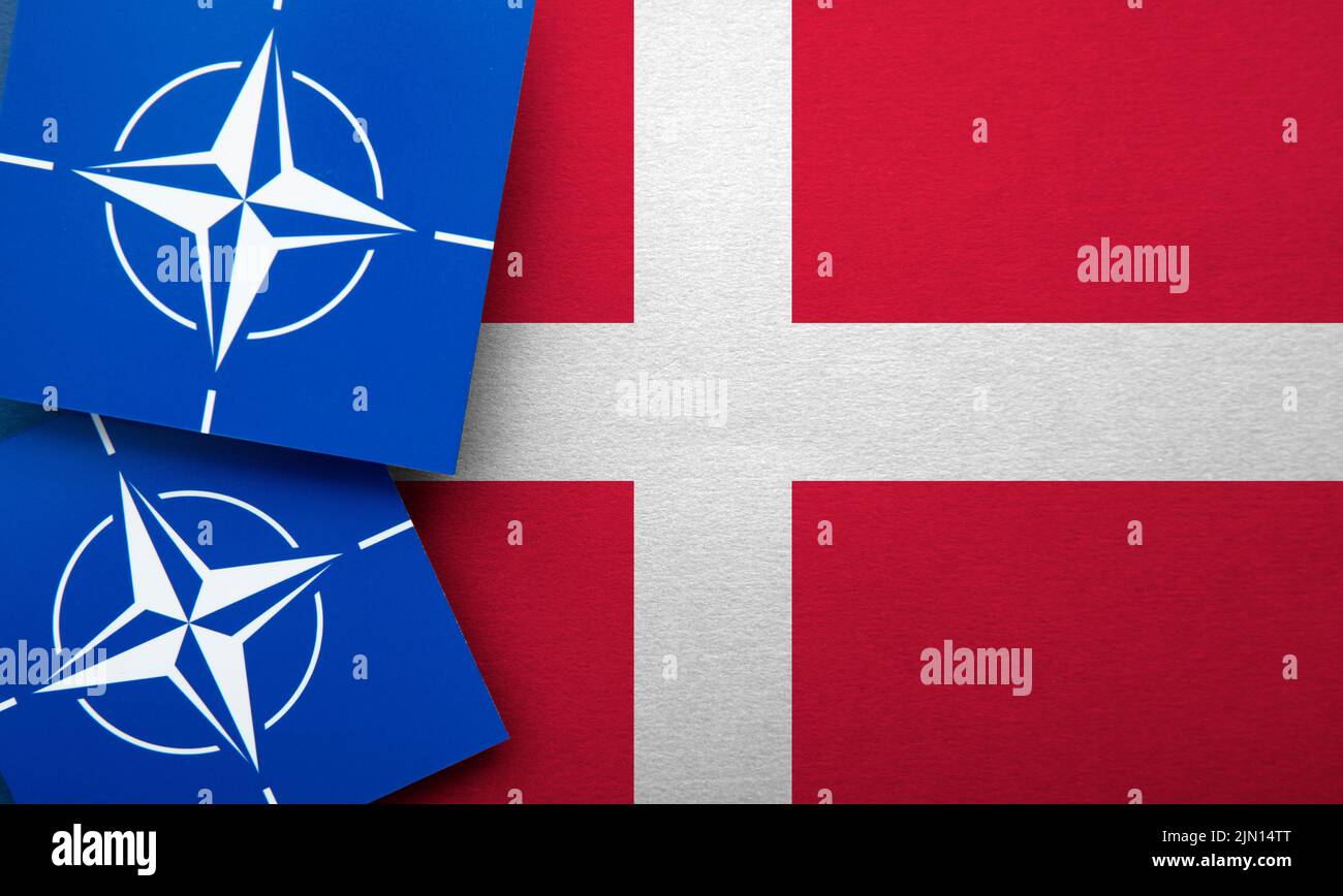 LONDRES, Reino Unido - Agosto de 2022: Logotipo de alianza militar de la Organización del Tratado del Atlántico Norte (OTAN) en una bandera de Dinamarca Foto de stock