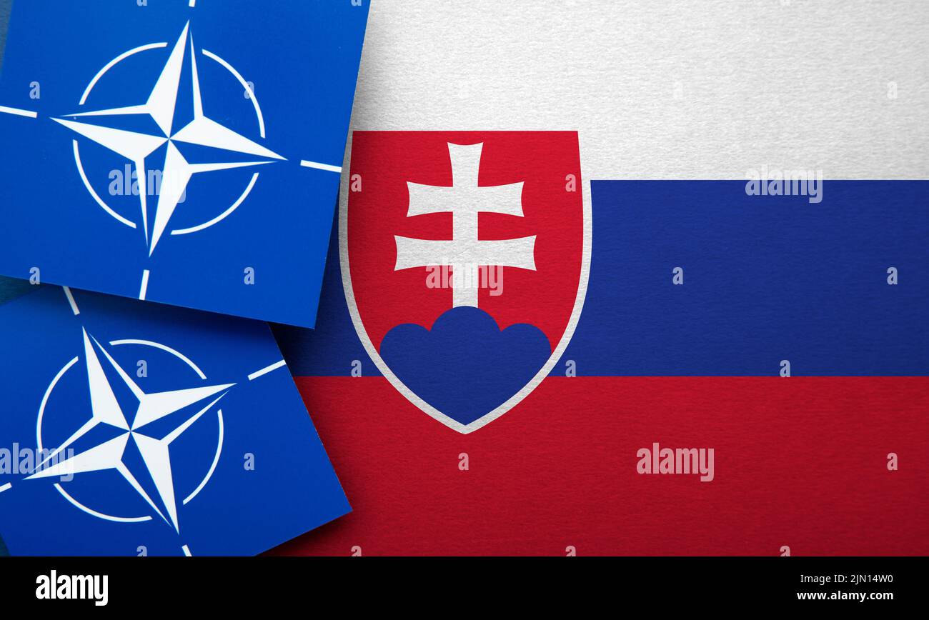 LONDRES, Reino Unido - Agosto de 2022: Logotipo de alianza militar de la Organización del Tratado del Atlántico Norte (OTAN) en una bandera de Eslovaquia Foto de stock