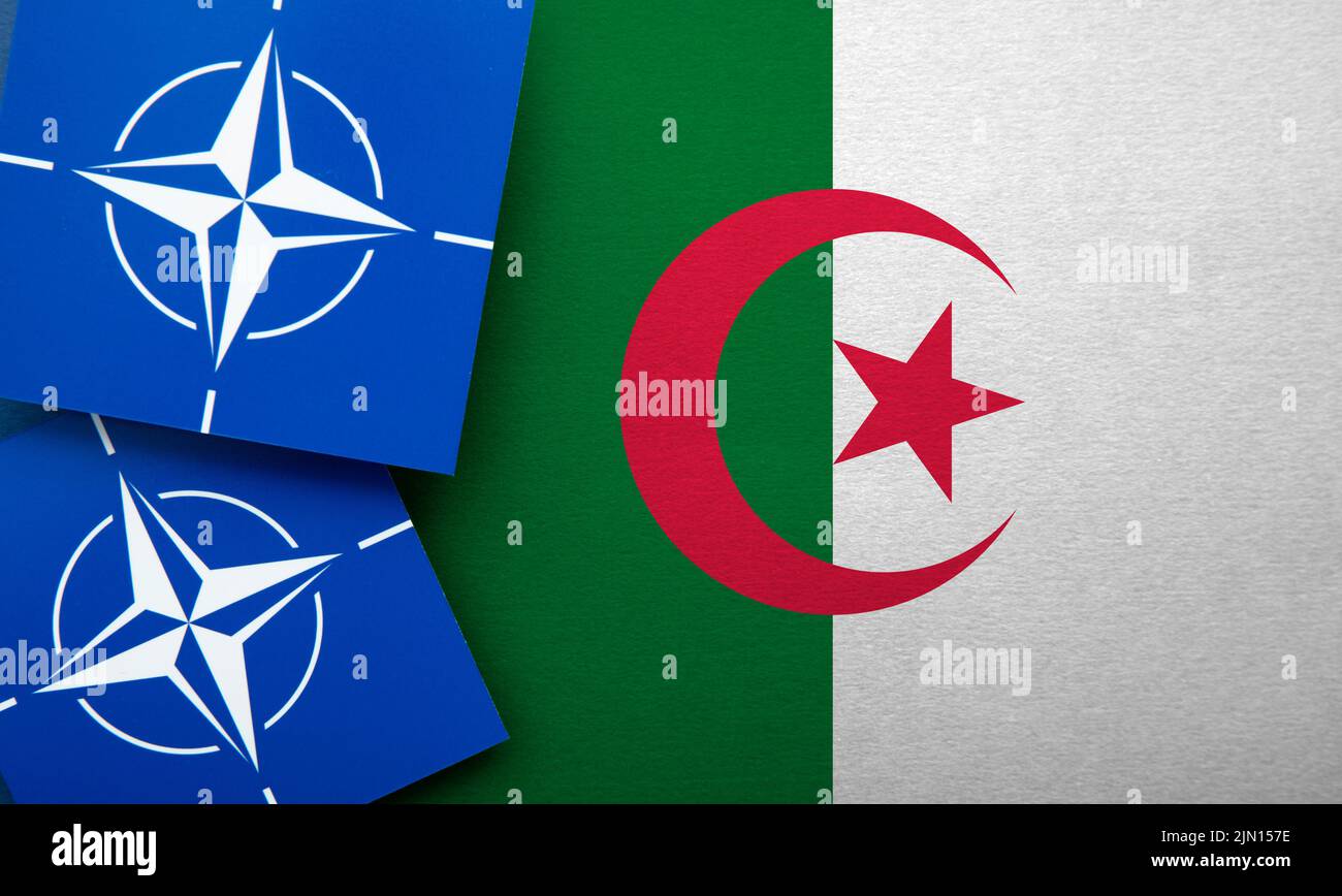 LONDRES, Reino Unido - Agosto de 2022: Logotipo de alianza militar de la Organización del Tratado del Atlántico Norte (OTAN) en una bandera de argelia Foto de stock