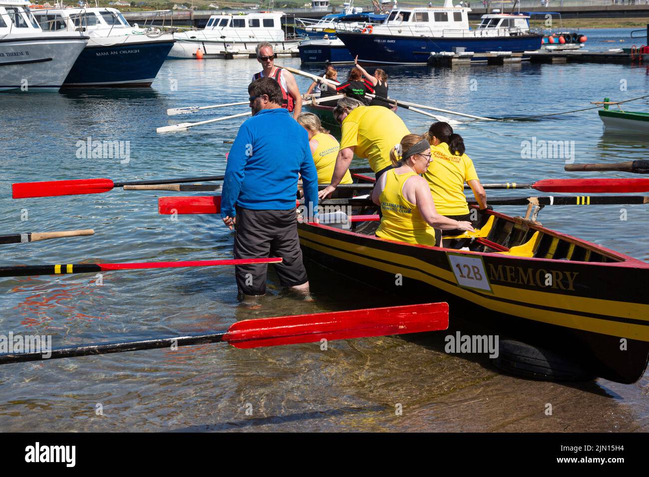 Bote de remo con tripulación femenina siendo lanzado. Portmagee Regatta, Condado de Kerry, Irlanda Foto de stock