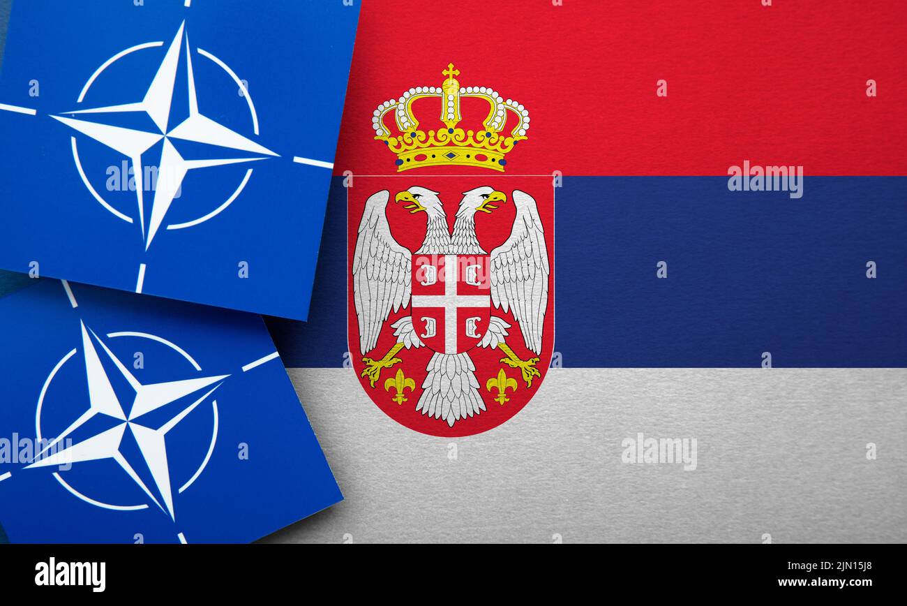 LONDRES, Reino Unido - Agosto de 2022: Logotipo de alianza militar de la Organización del Tratado del Atlántico Norte (OTAN) en una bandera de Serbia Foto de stock