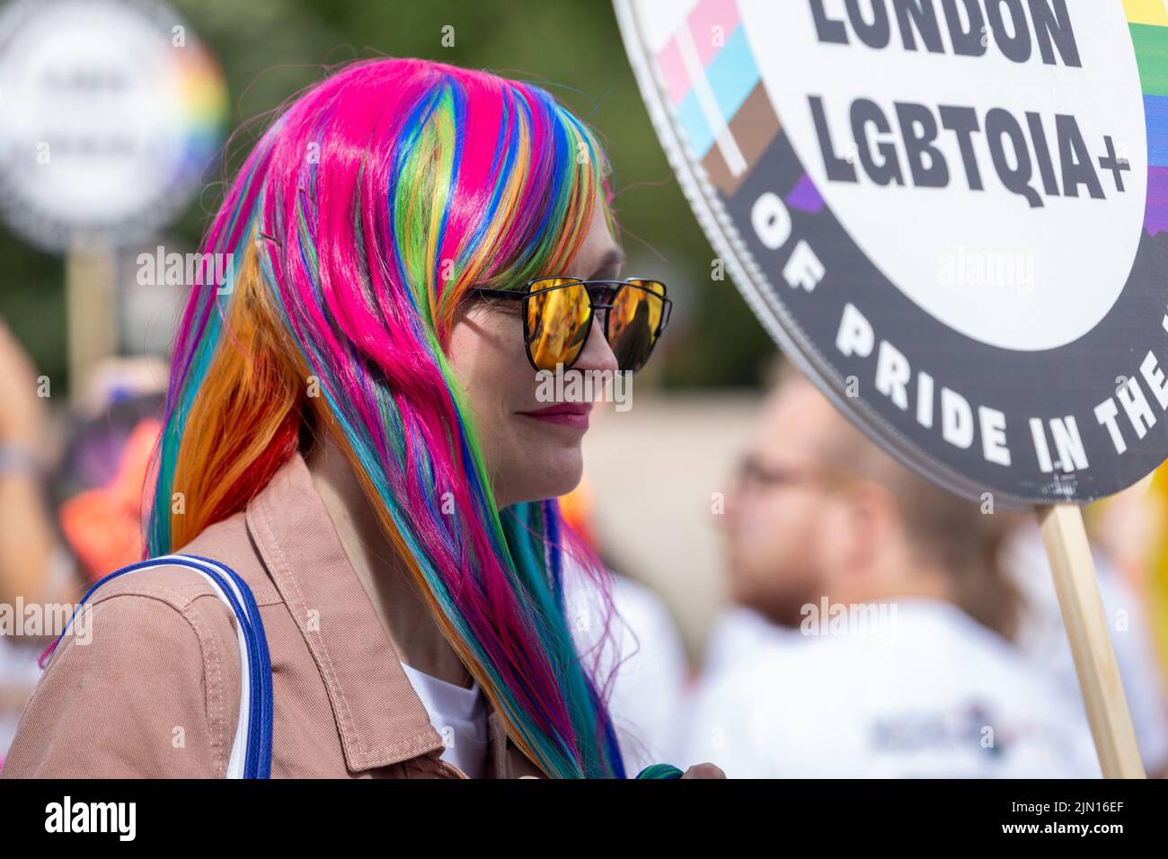 Una mujer de mediana edad con marchas de pelo rosa y arco iris en el London Pride 2022 Foto de stock