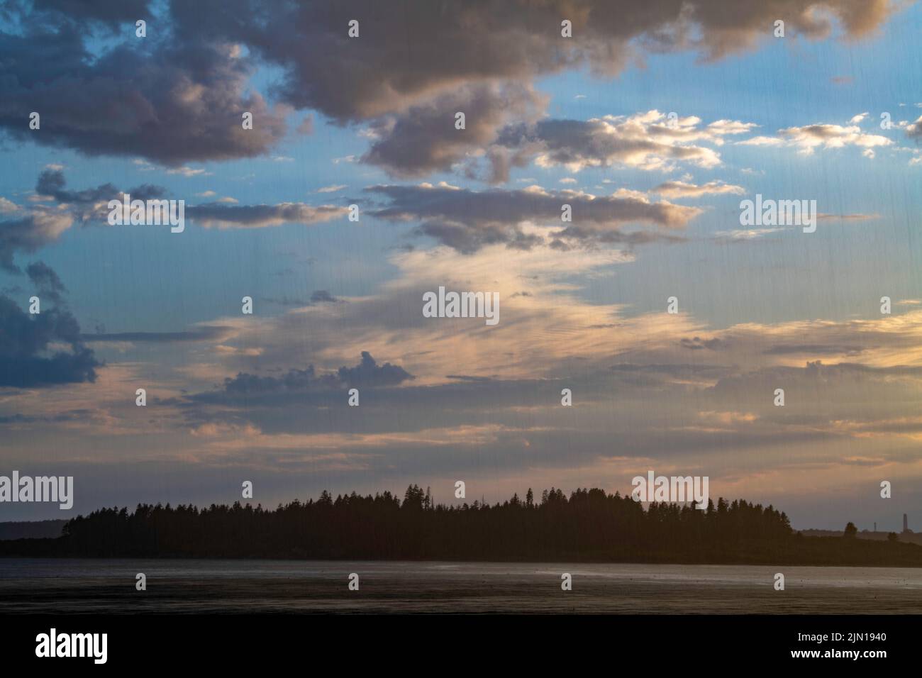 8 de julio de 2022. 7:47 pm. Lluvia y cielos despejados, juntos. Vista desde la Isla Barnes. Casco Bay, Maine. Serie Lluvia Storm. Foto de stock