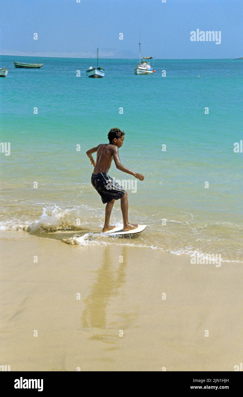 Niños con tablas de surf en la playa, Sal Rei, Boavista, Islas de Cabo Verde, África, Océano Atlántico Foto de stock