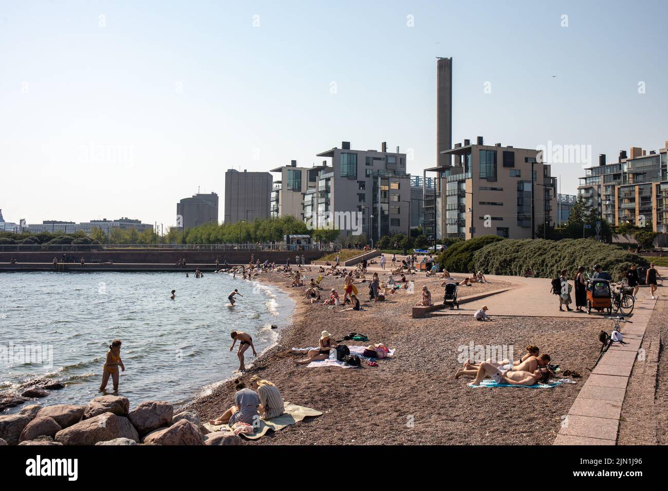 Gente bronceándose y nadando en Eiran ranta o en la playa de Eira en Helsinki, Finlandia Foto de stock