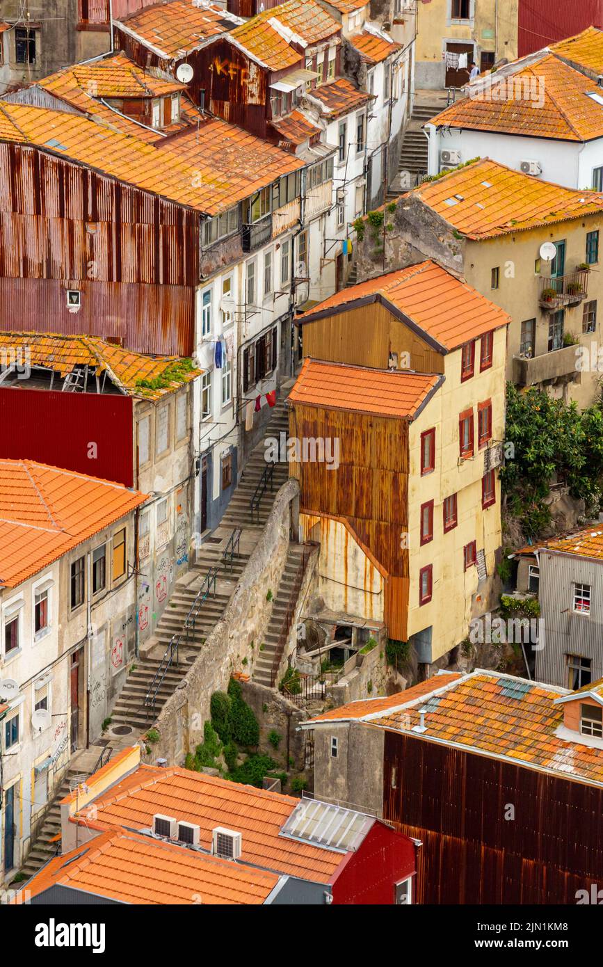 Contemple los tejados hacia las escaleras que se extienden entre edificios en el centro de Oporto, una de las principales ciudades del norte de Portugal. Foto de stock