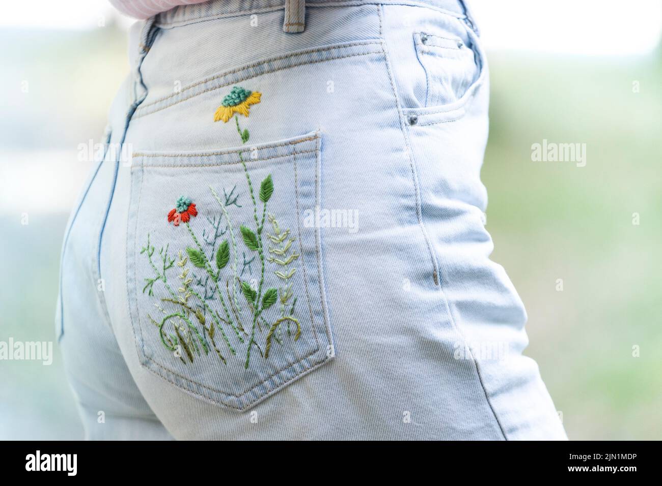 bolsillo bordado a mano sobre jeans. fondo floral Foto de stock