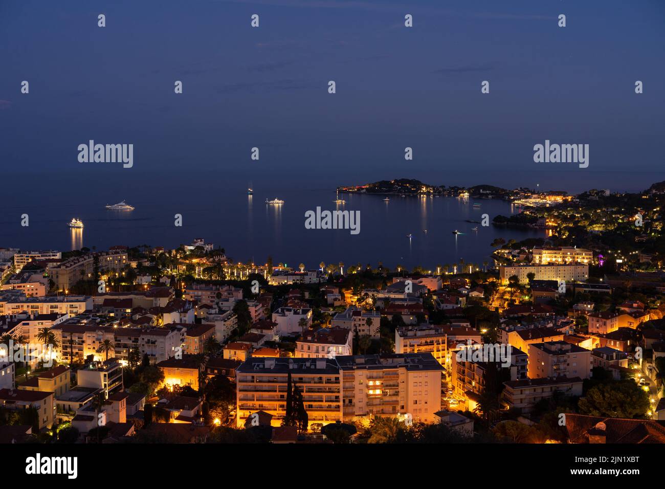 Panorama de la ciudad costera de Beaulieu-sur-Mer, Riviera Francesa - Côte d'Azur, por la noche, con Saint-Jean-Cap-Ferrat a la derecha Foto de stock