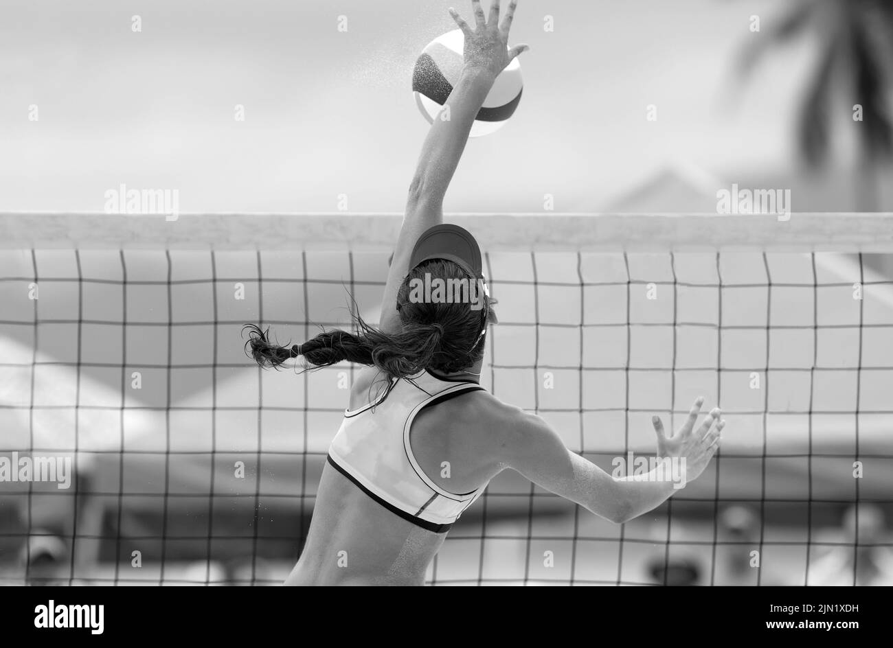 Un jugador de voleibol de playa está levantándose para Spike the Ball en blanco y negro Banner Image Format Foto de stock