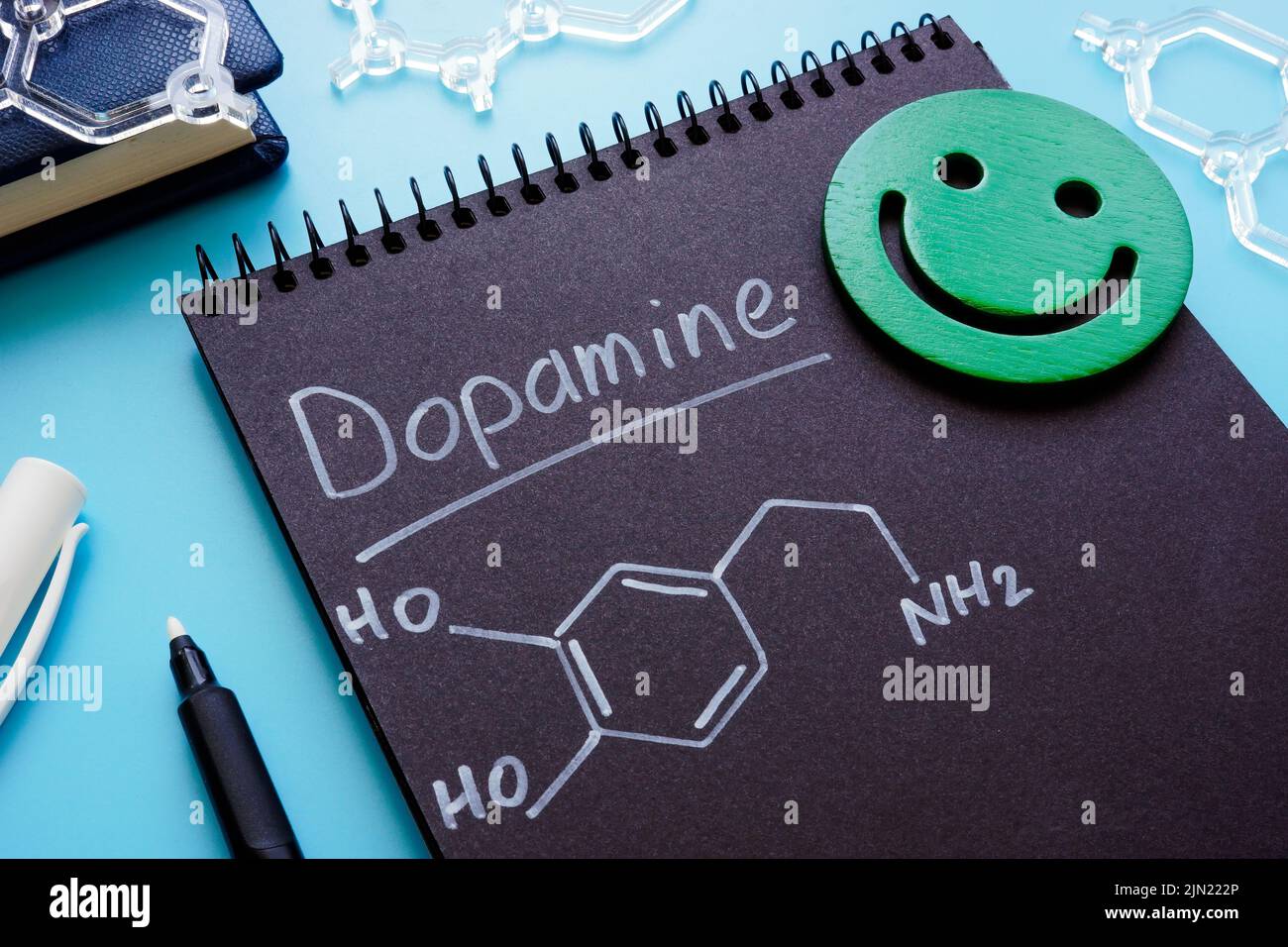 Fórmula química de la dopamina en la página oscura. Foto de stock