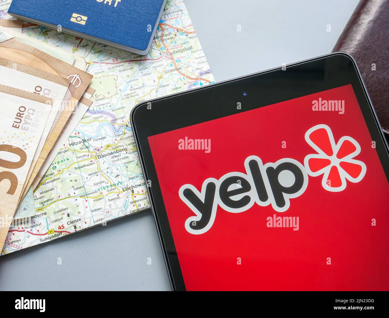 KIEV, UCRANIA - 21 de julio de 2022. Logotipo de Yelp Inc cerca de un mapa y dinero. Foto de stock