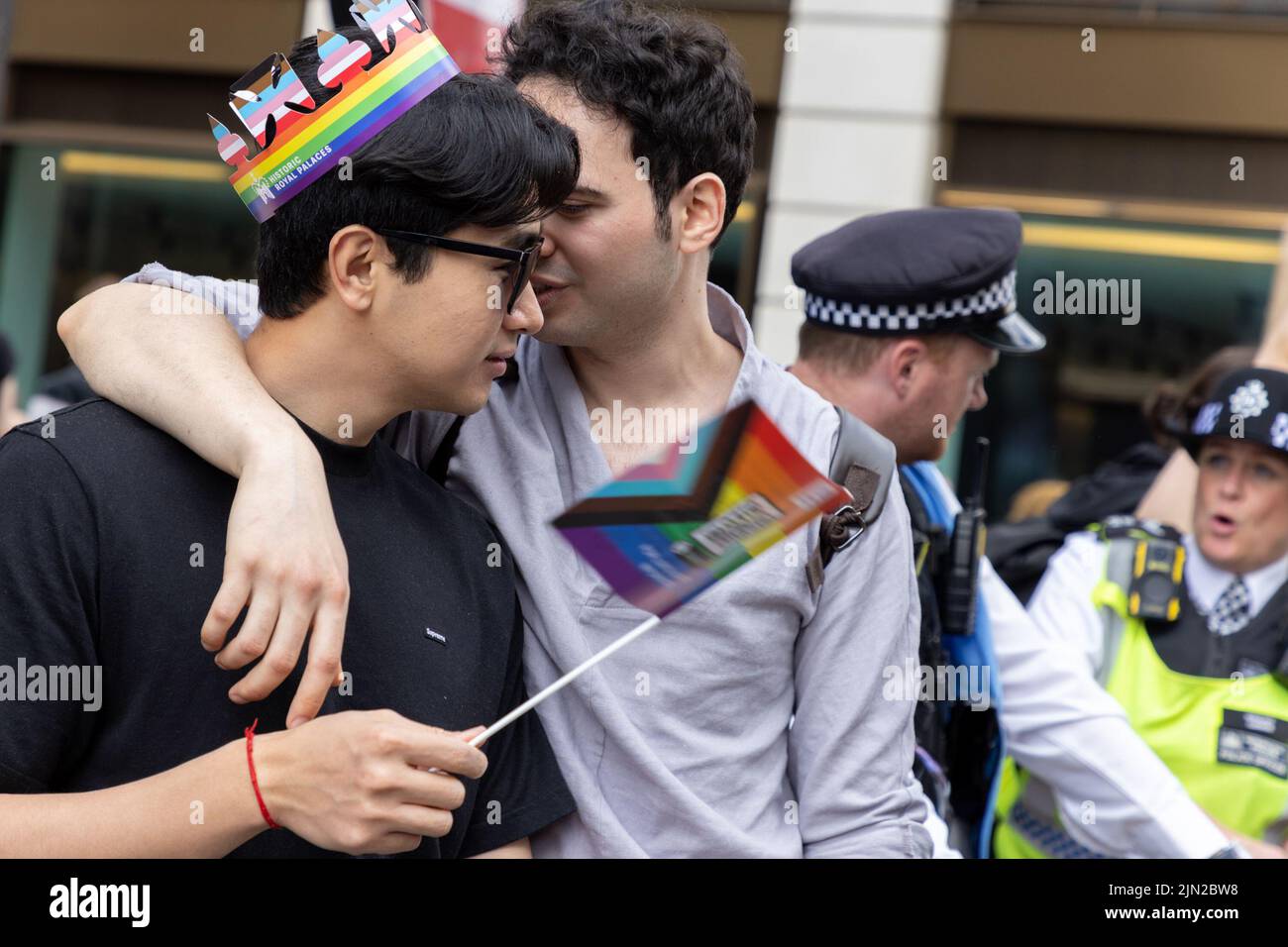 Los hombres demasiado jóvenes abrazan, a lo largo de las calles de Londres, Piccadilly en Pride London 2022. La marcha anual es una celebración para las lesbianas, gays, bisexuales Foto de stock