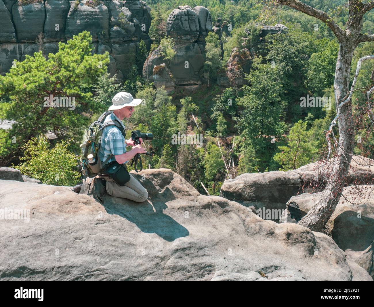 Schmilka - Alemania, 06 de julio de 2022: Turista con cámara está tomando fotos detrás del macizo de roca de Schrammsteine, Saxon Switzerland, Alemania. Vista desde th Foto de stock