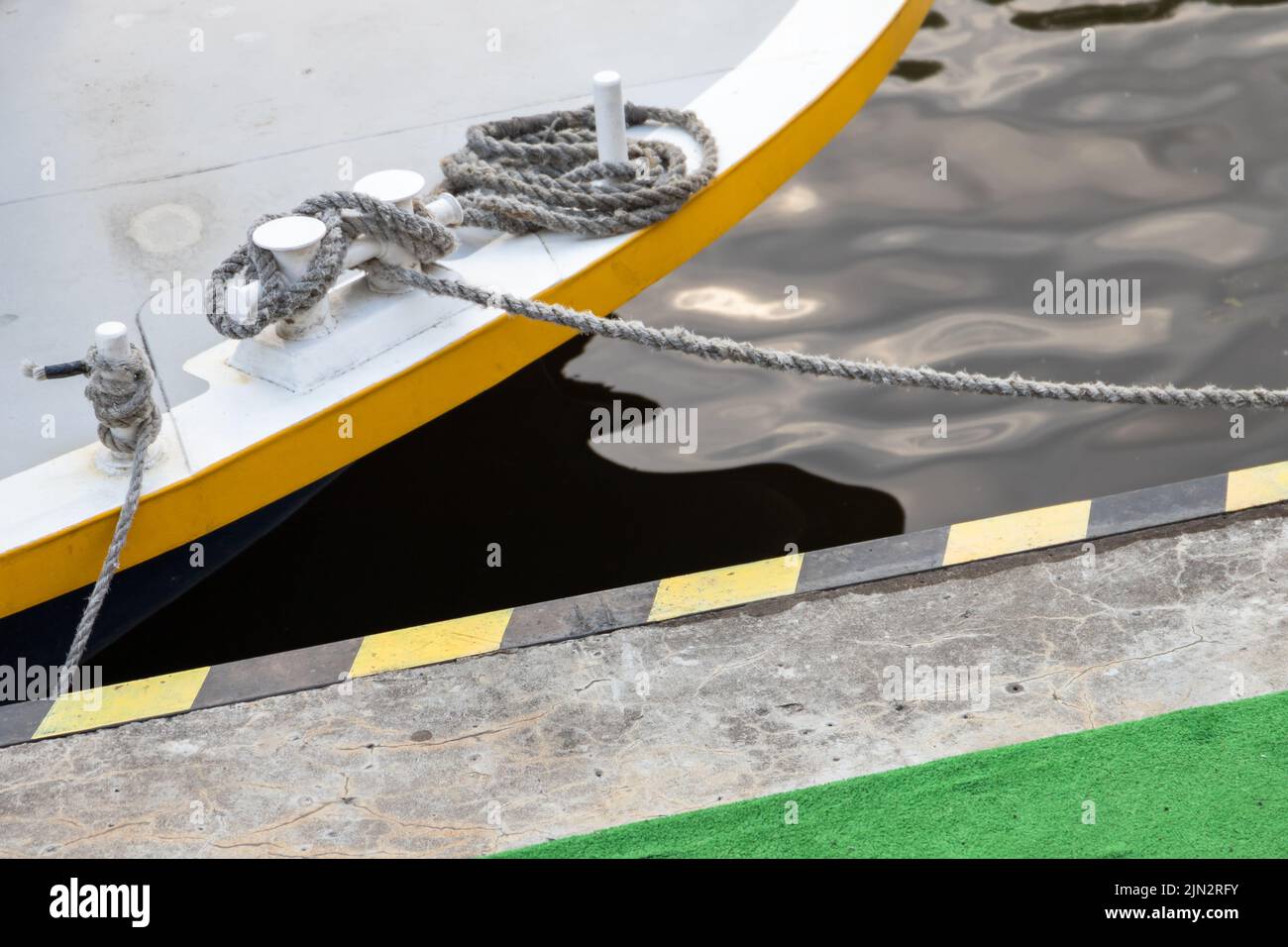 Los bolardos con cuerdas de amarre anudadas están en una cubierta del barco Foto de stock