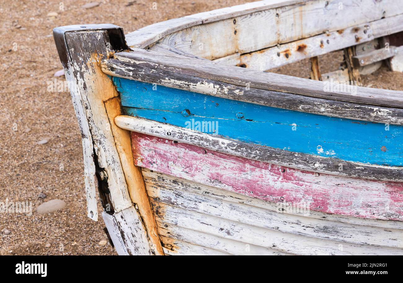 Arco de un viejo barco abandonado tumbado en una playa de arena Foto de stock